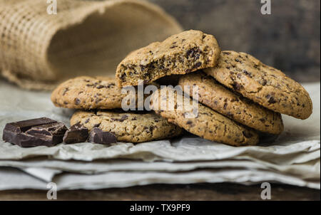 Les cookies au chocolat sortant du four sur du papier sulfurisé. Les Biscuits sucrés. Pâtisserie Maison. Banque D'Images