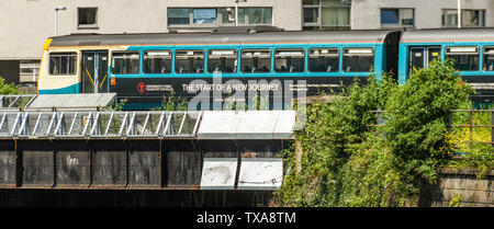 CARDIFF, WALES - Juin 2019 : train de banlieue en livrée provisoire du transport pour le pays de Galles traversant un pont dans le centre-ville de Cardiff Banque D'Images