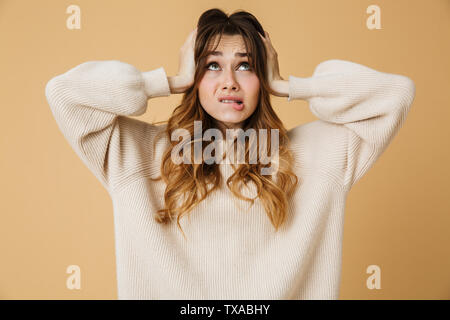 Belle confondu choqué young woman wearing sweater isolés sur fond beige Banque D'Images