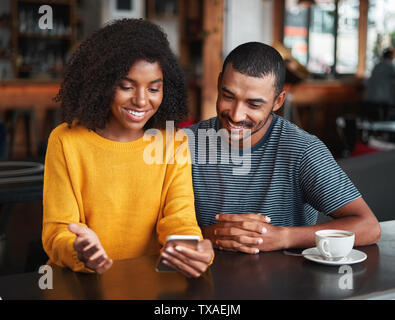 Jeune couple looking at mobile phone Banque D'Images