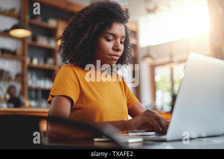 Jeune femme travaillant sur son ordinateur portable Banque D'Images