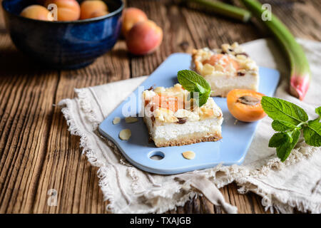 Abricot délicieux cheesecake à la rhubarbe, crumble surmonté de flocons d'amandes et Banque D'Images