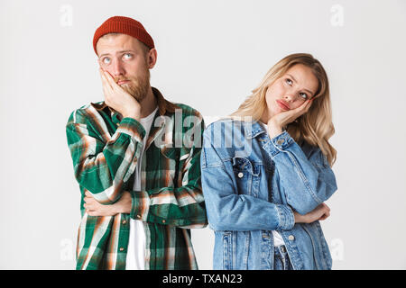 Photo d'un jeune couple aimant assez ennuyé posing isolated over white wall background. Banque D'Images