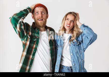 Photo d'un jeune couple aimant assez ennuyé posing isolated over white wall background. Banque D'Images