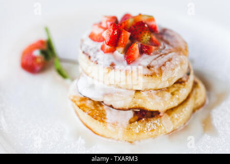 Crêpes aux fraises avec de la crème sur fond blanc close-up Banque D'Images