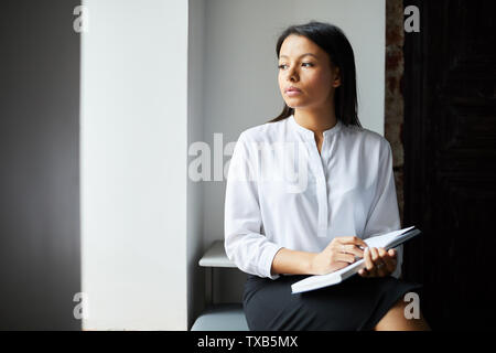 Portrait of mixed race woman black white nd à la fenêtre, songeur, à l'espace de copie Banque D'Images