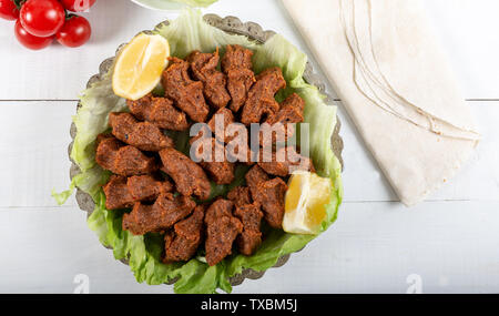 Cig Kofte alimentaire turc avec le citron, la laitue et le persil sur plaque d'argent Banque D'Images