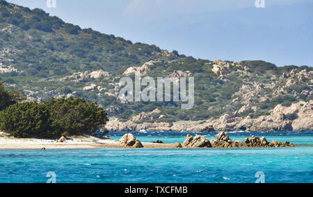 Une femme non identifiée est le soleil sur la belle plage de Cavalieri (Spiaggia di Cavalieri) baignée par une mer turquoise clair. Banque D'Images