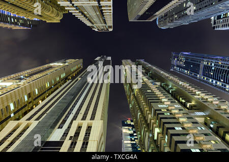 (Point de vue différent) Superbe vue du bas vers le haut de certains des gratte-ciel et tours allumés pendant la nuit à la Marina de Dubaï. Banque D'Images