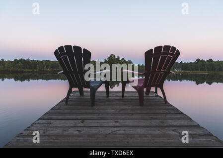 Deux chaises Adirondack assis sur un quai - Muskoka, Ontario, Canada. Banque D'Images
