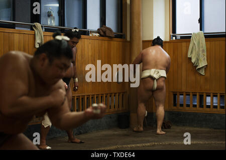 Plusieurs athlètes de divers grades réchauffer et la pratique sumène lutte lors d'une petite écurie de sumo à Tokyo, Japon. Banque D'Images