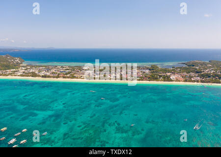 De nombreux bateaux de touristes près de l'île de Boracay. Seascape Aux Philippines par temps ensoleillé, vue de dessus. Une grande île densément peuplée avec des hôtels et d'une plage de sable blanc. Banque D'Images