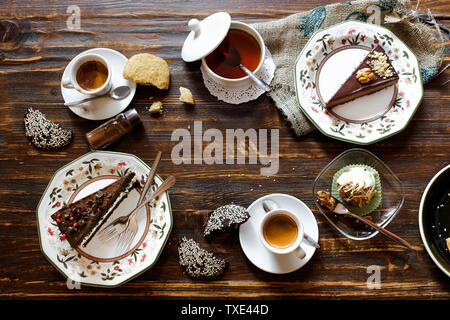 Les gâteaux au chocolat, flatlay la composition, l'espace négatif, café, tasses, assiettes floral blanc, cookies, surface en bois, petit déjeuner Banque D'Images
