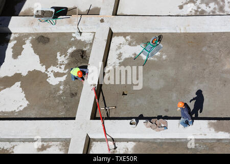 Les travailleurs en uniforme sable propre sur un site de construction, vue d'en haut. Banque D'Images