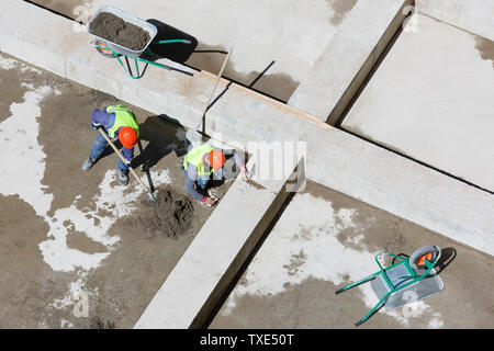 Les travailleurs en uniforme sable propre sur un site de construction, vue d'en haut. Banque D'Images