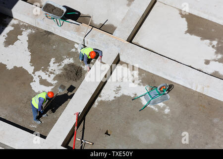 Les travailleurs en uniforme sable propre sur un site de construction, vue d'en haut. Banque D'Images