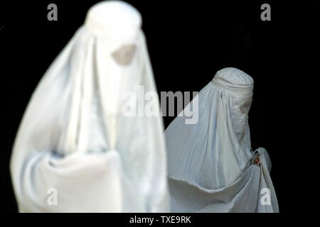 Les femmes vêtues de la burqa blanche quitter la mosquée Bleue après leurs prières à Mazar-e-Sharif (la tombe de l'Exalté), Afghanistan, le 24 août 2009. Durant le mois de Ramadan, le neuvième mois du calendrier islamique, les Musulmans s'abstiennent de manger, de boire et de fumer du lever au coucher du soleil. Mazar-e-Sharif est la quatrième plus grande ville d'Afghanistan et se trouve au nord. UPI/Mohammad Kheirkhah Banque D'Images