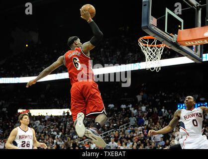 Avant Miami Heat LeBron James (6) dunks sur Atlanta Hawks' Kyle Korver (26) et Jeff Teague dans la deuxième moitié de leur basket de la NBA à la Philips Arena d'Atlanta, le 20 février 2013. Miami a remporté103-90. UPI/David Tulis Banque D'Images