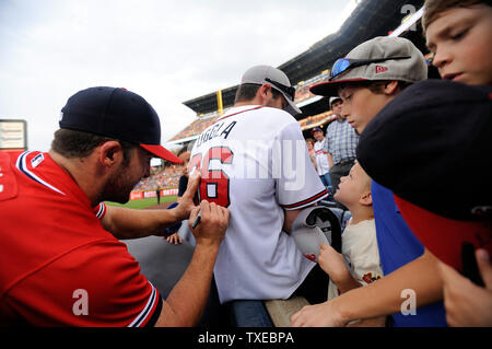 Le deuxième but des Braves d'Atlanta Dan Uggla signe la chemise de son ami Sean Carlson avant que l'équipe fait face à l'Cardinals de Saint-Louis à Turner Field à Atlanta, le 26 juillet 2013. UPI/David Tulis Banque D'Images