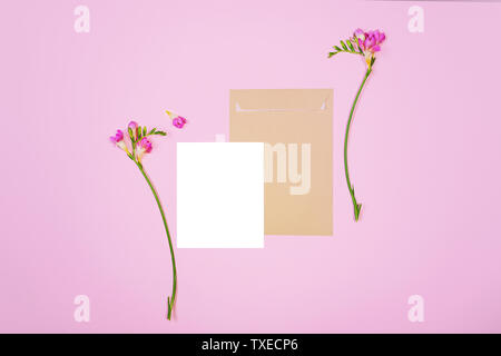 Télévision de laïcs lettre feuille et papier enveloppe écologique sur fond rose. Cartes d'invitation ou lettre d'amour avec Lily rose des fleurs. Banque D'Images