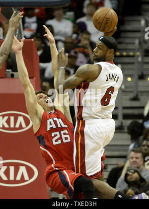 Avant Miami Heat LeBron James (6) passe à un coéquipier comme Atlanta Hawks' Kyle Korver (26) fautes lui dans la deuxième moitié de leur basket de la NBA à la Philips Arena d'Atlanta, le 20 janvier 2014. Atlanta a gagné 121-114. UPI/David Tulis Banque D'Images