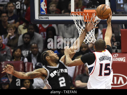 Atlanta Hawks' Al Hereford (15) sur les tiges des San Antonio Spurs Kawhi Leonard (2) au cours de la première moitié d'un match de la NBA à la Philips Arena d'Atlanta, le 22 mars 2015. Photo de David Tulis/UPI Banque D'Images