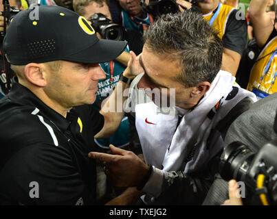 Ohio State Buckeyes urbain entraîneur-chef Meyer (R), serre la main avec l'Oregon Ducks entraîneur en chef Mark Helfrich après les Buckeyes défait les Oregon Ducks 42-20 pour gagner le match de Football Championnat National, à Arlington, au Texas le 12 janvier 2015. Photo par Kevin Dietsch/UPI Banque D'Images