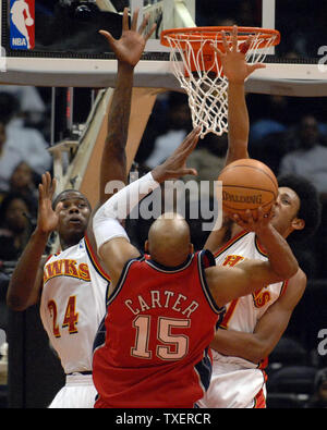 New Jersey Nets Vince Carter (15) tente pour deux sur les mains d'Atlanta Hawks Marvin Williams (24) et Josh Childress (1) dans la quatrième période au Philips Arena d'Atlanta, le 7 février 2007. Carter a mené son équipe avec 22 points. Les filets défait les Hawks 87-85. (Photo d'UPI/John Dickerson) Banque D'Images