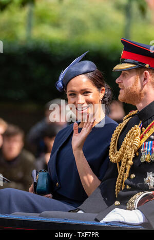 Meghan Markle, duchesse de Sussex, brandissant d'une calèche ouverte avec le prince Harry en uniforme à Trooping the Colour 2019. Contact visuel Banque D'Images