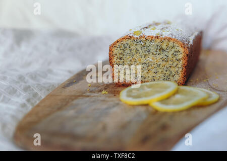 Gâteau aux Graines de pavot et le zeste de citron, saupoudrés de sucre en poudre. Cupcake au citron sur une planche en bois Banque D'Images