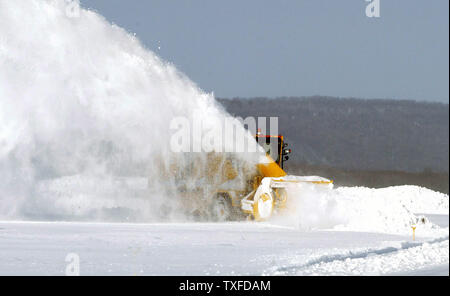 Un véhicule de la soufflante à neige projette la neige sur le côté, comme il dégage une piste, à l'aéroport international de Bradley, comme une histoire d'hiver lourds diminue, après le déversement de jusqu'à 18' de la neige dans la région, dimanche, 7 décembre 2003, Windsor Locks, Connecticut) La tempête d'hiver de nombreux passagers bloqués tout au long de la côte est que les vols ont été retardés ou annulés en raison des conditions météo. (UPI Photo / Steven E. Frischling) Banque D'Images