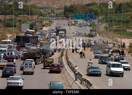 Les civils libanais tentent de faire leur chemin comme ils sont arrêtés par un pont bombardé près de la ville Dammour dans le sud de Beyrouth, heures après un cessez-le-feu négocié par l'ONU s'est rendu sur les effets le lundi 14 août 2006. Après le cessez-le-feu entre en vigueur à 08:00 (05:00 GMT) Heure locale, des dizaines de milliers de réfugiés libanais emballé leurs choses et dirigé dans leurs foyers dans le sud du Liban. UPI (photo) Banque D'Images