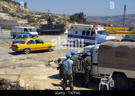 Les gardiens de la paix des Nations Unies indiennes un homme occupé avec contrôle des soldats libanais (arrière-plan) près de la frontière libanaise, village de Kfar Kila le 30 août 2006. L'Organisation des Nations Unies espère disposer d'armées près de 15 000 pour aider à la patrouille de l'armée libanaise au sud du Liban. UPI (photo) Banque D'Images