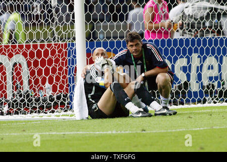 Fabien Barthez gardien français (L) siège contre le poteau de but après que son équipe a manqué la Coupe du Monde à la pénalité shoot out contre l'Italie dans la finale de la Coupe du Monde à Berlin le 9 juillet 2006. L'Italie a gagné 5-3. (Photo d'UPI/Arthur Thill) Banque D'Images