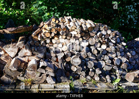 Un tas de bois de chauffage fendu et haché plein de bois de chauffage sec prêt à graver pour l'hiver. Banque D'Images