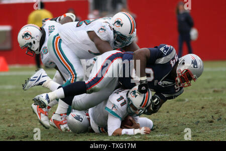 Le joueur de ligne défensive des Patriots de la Nouvelle-Angleterre Ty Warren saute sur Miami Dolphins quarterback Gus Frerotte secondeur Tully Banta-Cain comme des patriotes obtient dans le sac pour au Stade Gillette de Foxboro, MA le 1 er janvier 2006. (Photo d'UPI/Katie McMahon) Banque D'Images