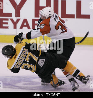 Centre des Flyers de Philadelphie Darroll Powe (36) renverse le centre des Bruins de Boston Patrice Bergeron (37) dans la troisième période de Match 7 de la demi-finale de conférence de l'Est de la LNH au TD Garden de Boston, Massachusetts le 14 mai 2010. Les Flyers ont battu les Bruins 4-3. UPI/Matthew Healey Banque D'Images