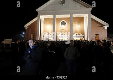 Un correspondant de la télévision Europe rapports devant une grande foule rassemblée pour une veillée aux chandelles à la Sainte Rose de Lima l'Église catholique romaine à Newtown, Connecticut à la suite d'une fusillade qui a fait au moins 26 morts dont 18 enfants à l'École Sandy Hook plus tôt dans la journée le 14 décembre 2012. Un homme armé a ouvert le feu à l'intérieur à l'intérieur de l'école élémentaire de Sandy Hook tôt vendredi matin où sa mère travaillait. Le suspect de 20 ans, Adam Lanza, qui aurait été tué lui-même après la fusillade à l'intérieur de l'école. UPI/Matthew Healey Banque D'Images