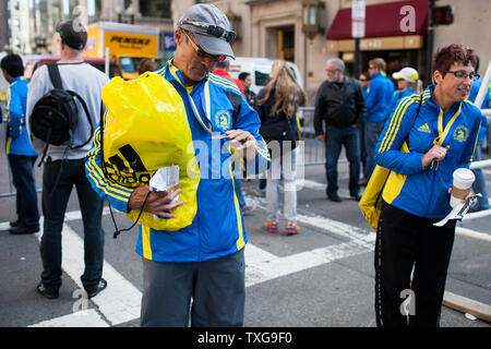 Pat Monroe, gauche, de Winterhaven, Floride, regarde sa médaille Marathon de Boston après avoir reçu le prix avec ses affaires d'un pâté de maisons de la ligne d'arrivée du marathon le mardi 16 avril 2013. Monroe avec sa femme Laura, droite, ont été les premiers à venir chercher leurs effets personnels après l'attentat d'hier sur la ligne d'arrivée où les Monroes étaient que moins d'un 1/2 mile de la finition. Lundi's twin explosif sur la ligne d'arrivée du Marathon de Boston ont tué trois et blessé plus de 175. UPI/Jacob Belcher Banque D'Images