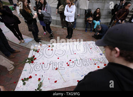 Les gens restent debout autour d'une banderole signée lors d'une veillée aux chandelles organisée à Boston Common à Boston, Massachusetts le 16 avril 2013. La veillée est en réponse à l'explosif sur Boylston Street près de la ligne d'arrivée du Marathon de Boston lundi après-midi, tuant 3 et en blessant 150. UPI/Matthew Healey Banque D'Images