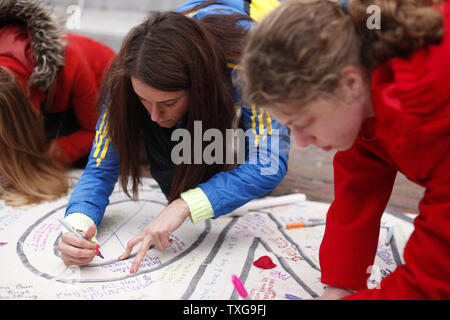 Les gens signer une bannière lors d'une veillée aux chandelles organisée à Boston Common à Boston, Massachusetts le 16 avril 2013. La veillée est en réponse à l'explosif sur Boylston Street près de la ligne d'arrivée du Marathon de Boston lundi après-midi, tuant 3 et en blessant 150. UPI/Matthew Healey Banque D'Images