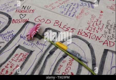 Une fleur repose sur une banderole signée lors d'une veillée aux chandelles organisée à Boston Common à Boston, Massachusetts le 16 avril 2013. La veillée est en réponse à l'explosif sur Boylston Street près de la ligne d'arrivée du Marathon de Boston lundi après-midi, tuant 3 et en blessant 150. UPI/Matthew Healey Banque D'Images