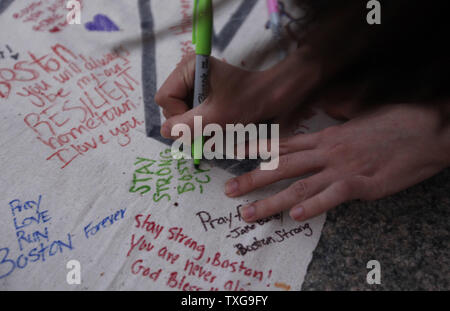 Les gens signer une bannière lors d'une veillée aux chandelles organisée à Boston Common à Boston, Massachusetts le 16 avril 2013. La veillée est en réponse à l'explosif sur Boylston Street près de la ligne d'arrivée du Marathon de Boston lundi après-midi, tuant 3 et en blessant 150. UPI/Matthew Healey Banque D'Images