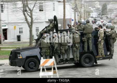 Les membres de l'équipe SWAT sont poussés vers le bas Melendy Avenue à l'arrière d'un véhicule blindé au cours d'une chasse à l'homme massive pour l'un des deux suspects attentat du Marathon de Boston le 19 avril 2013. L'attentat du Marathon de Boston lundi a fait trois morts et plus de 170 blessés. UPI/Matthew Healey Banque D'Images