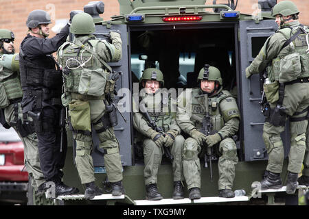 Les membres de l'équipe SWAT sont poussés vers le bas de la rue de l'École de Watertown, Massachusetts dans l'arrière d'un véhicule blindé au cours d'une chasse à l'homme massive pour l'un des deux suspects attentat du Marathon de Boston le 19 avril 2013. L'attentat du Marathon de Boston lundi a fait trois morts et plus de 170 blessés. UPI/Matthew Healey Banque D'Images