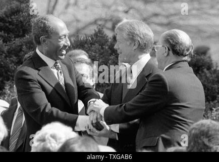 Le président égyptien Anouar El Sadate, le président américain Jimmy Carter et le Premier Ministre israélien Menahem Begin se serrent la main au moment du traité de paix entre Israël et l'Égypte en 1979 Banque D'Images