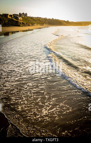 WHITBY en Angleterre. Les gens qui marchent sur la plage de Whitby sur une belle journée ensoleillée et venteuse. Dans la région de Whitby, North Yorkshire, Angleterre. Banque D'Images