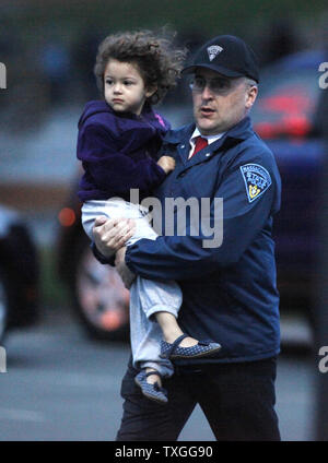 Un état policier évacue l'enfant près de l'endroit où suspect Tsarnaev Djokhar, 19 ans, est troué vers le haut sur la course près de Franklin Street à Watertown, Massachusetts, près de Boston le 19 avril 2013. Des coups de feu ont été tirés. Son frère Tamerlan Tsarnaev, 26 ans, a été tué par la police la nuit dernière. Tous deux de Cambridge, Massachusetts sont les bombardiers de la marathon de Boston le 15 avril 2013. UPI/Matt Healey Banque D'Images