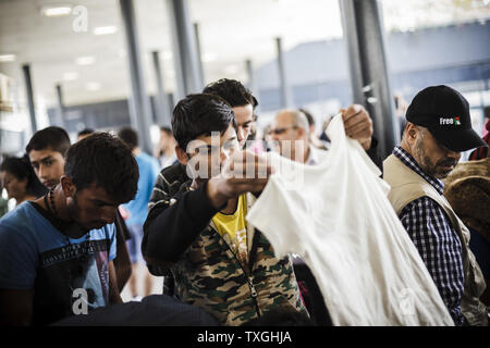 République et d'autres migrants ramasser certaines fournitures avant de bord d'un train commercial en direction de Vienne dans la gare Keleti de Budapest, Hongrie le 6 septembre 2015. Photo par Zavallis-81/UPI Banque D'Images