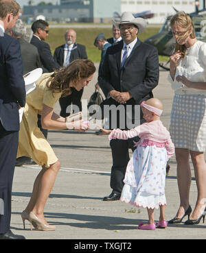 Pour la dernière étape de leur tournée royale, le Prince William regarde son épouse Kate recevoir un cadeau d'une personne atteinte de cancer et la bouquetière Diamond au cours de la Marshall duc et duchesse de Cambridge par l'arrivée de l'hélicoptère militaire pour leur casquette blanche cérémonie tenue à Calgary, Alberta, le 7 juillet 2011. UPI/Heinz Ruckemann Banque D'Images